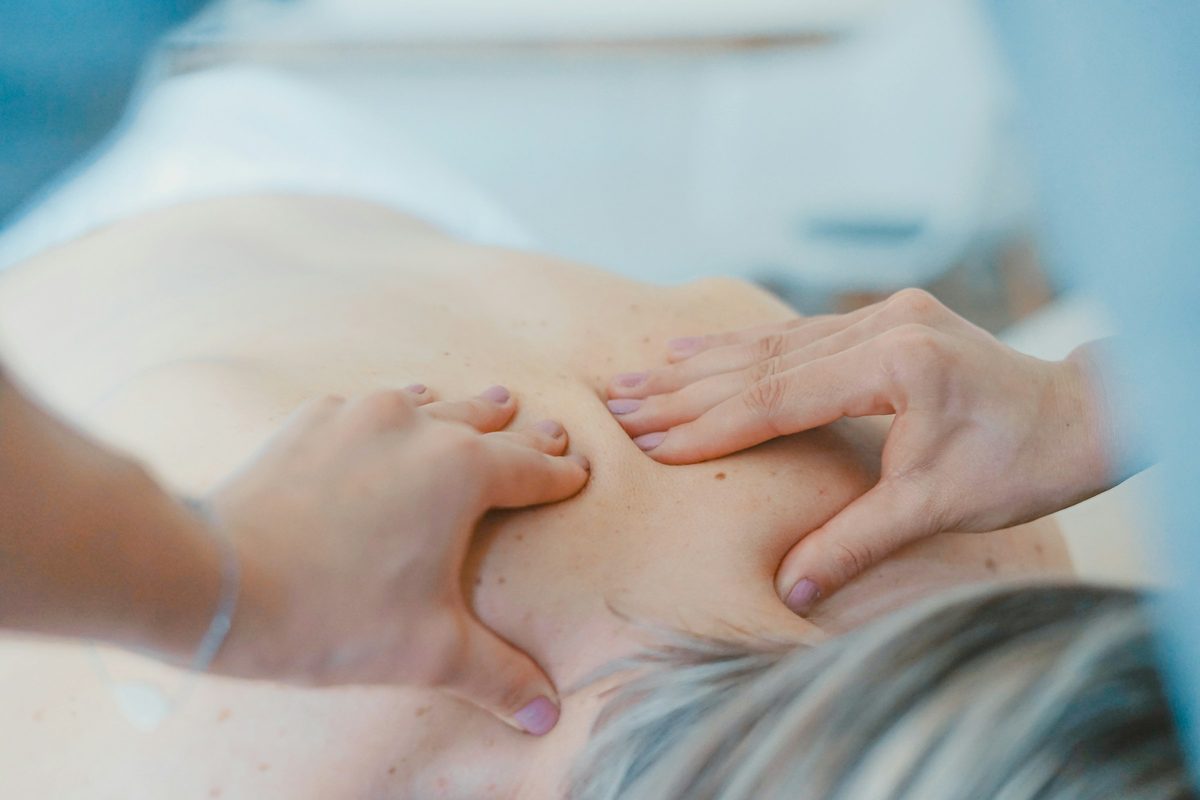 Terapeuta dando un masaje en la espalda a una clienta